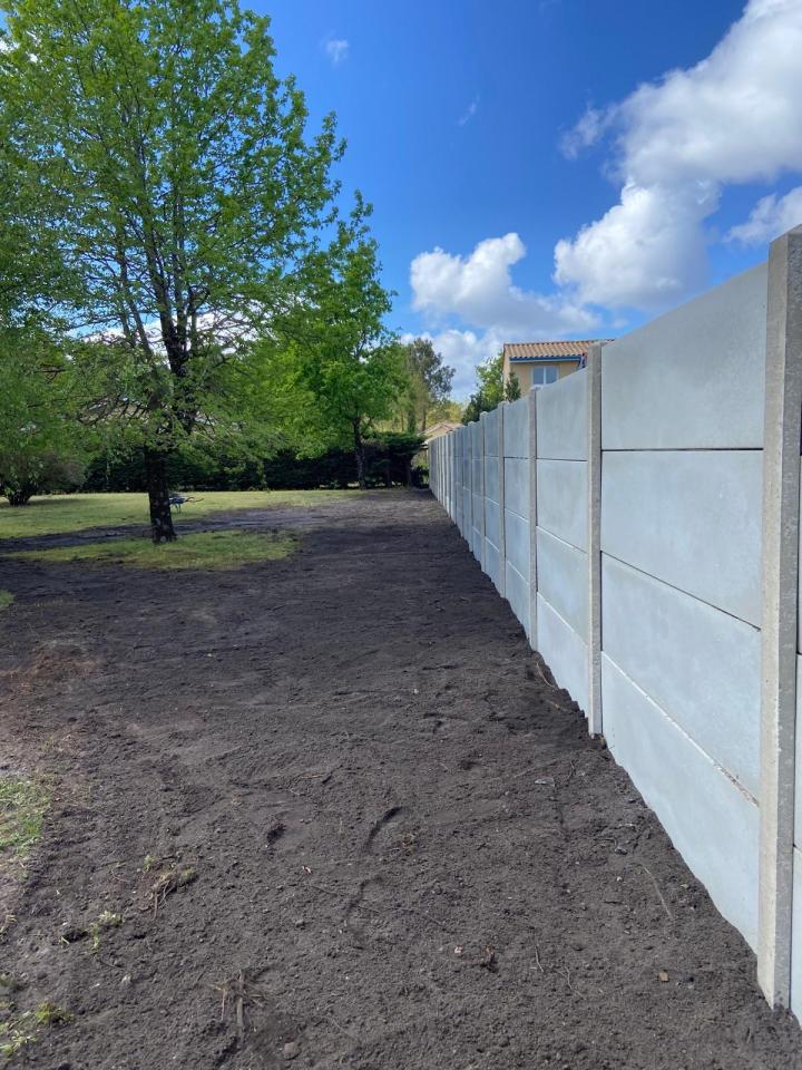 Clôture poteaux et plaques béton.